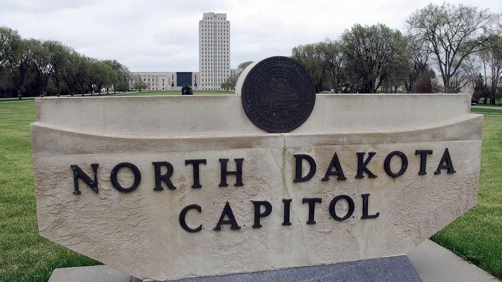 PHOTO: FILE - The North Dakota Capitol tower rises in the background behind a stone sign, April 19, 2012, in Bismarck, N.D.