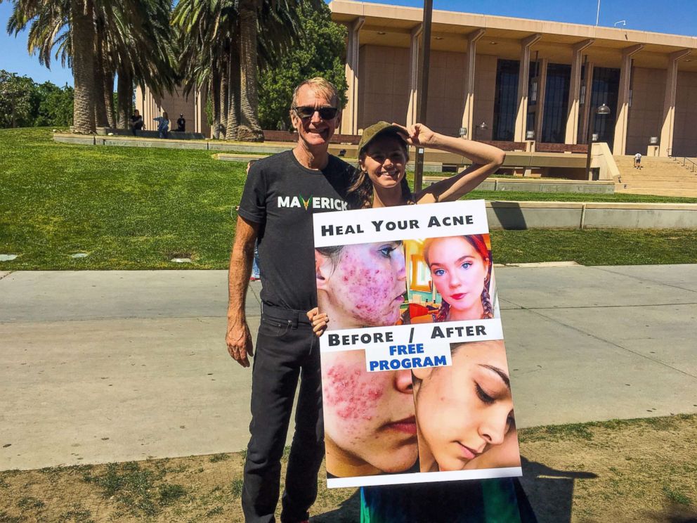 PHOTO: Nina Nelson and her father, Jeff Nelson, pose with a sign recruiting college students.