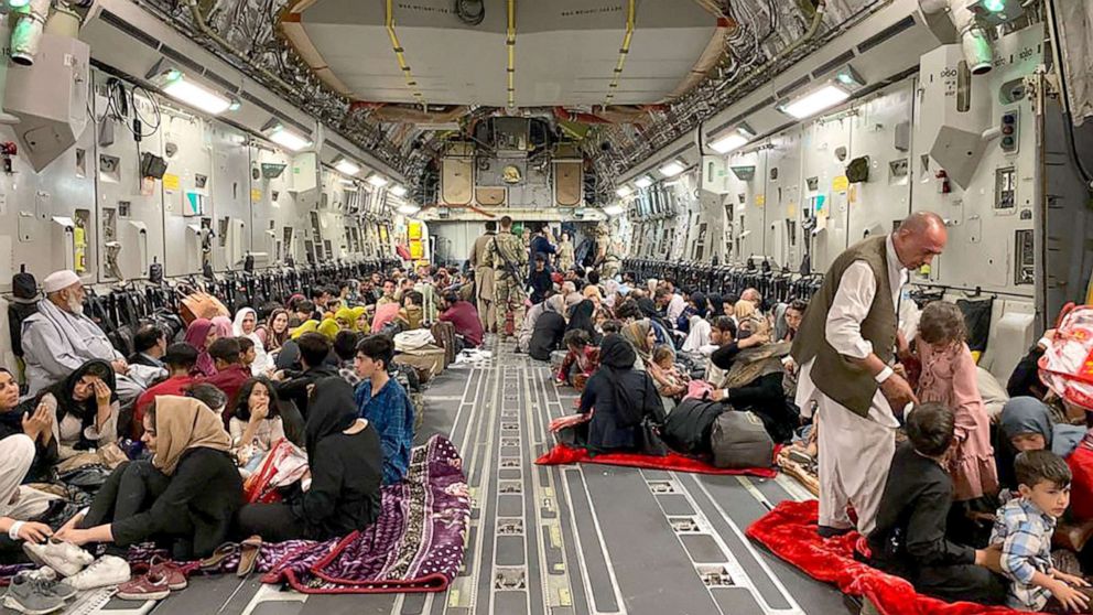 PHOTO: Afghan people sit inside a U.S military aircraft to leave Afghanistan, at the military airport in Kabul on Aug. 19, 2021 after Taliban's military takeover of Afghanistan. 