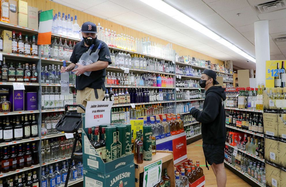PHOTO: Frankie Arguinzni, an employee at Supreme Liquor, gets down bottles of vodka from the top shelf for a customer in the Cambridge, Mass., April 28, 2020.