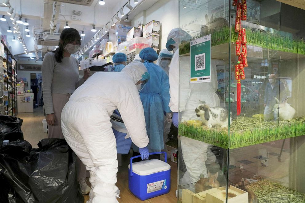 PHOTO: Officers in protective suits work inside a closed pet shop in Mong Kok district after a hamster cull was ordered to curb the coronavirus disease (COVID-19) outbreak, in Hong Kong, Jan. 19, 2022.
