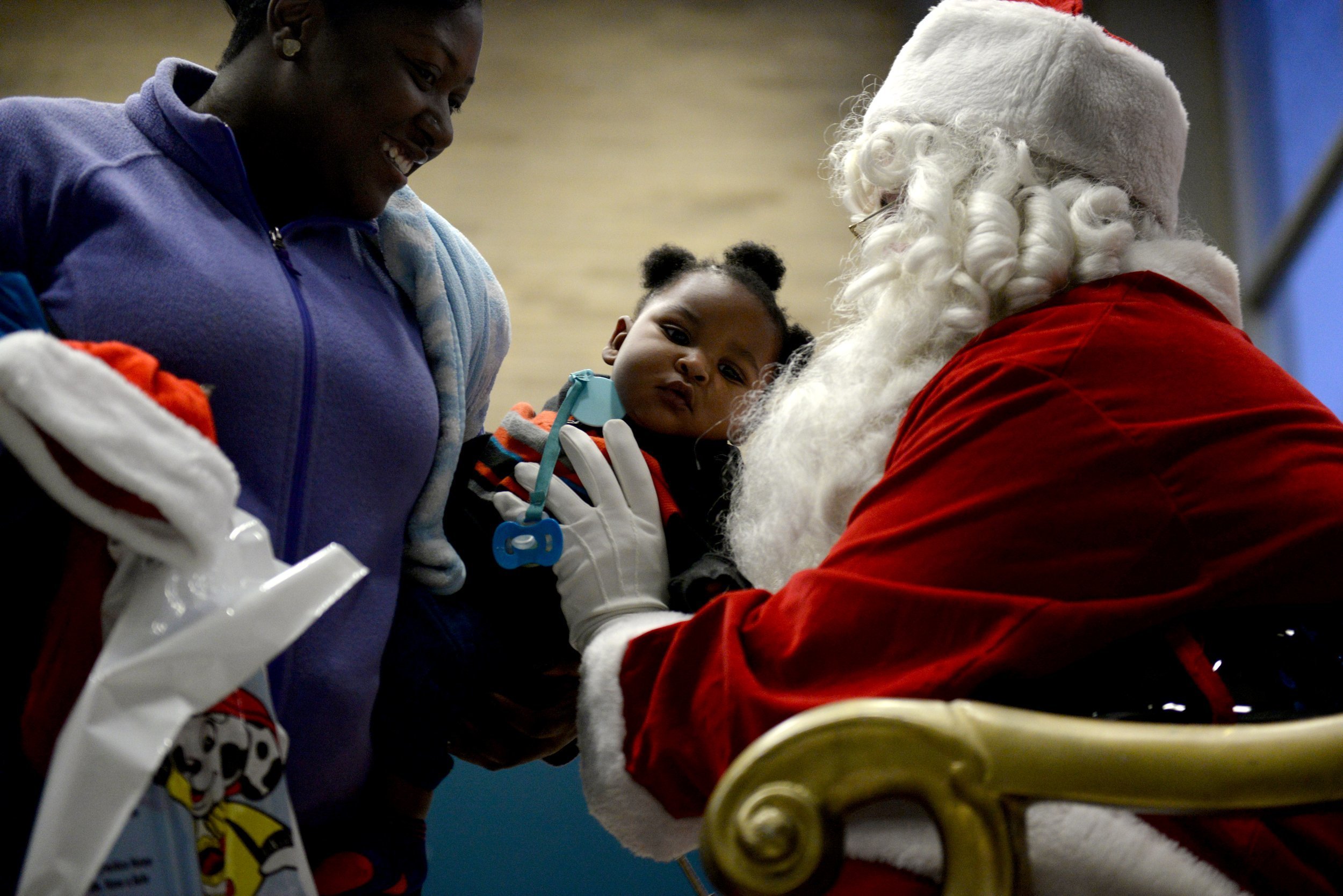 PHOTO: Kylan Pouncil, 10 months,  is passed to Santa Claus as members of the community gather for a tree lighting on Dec. 2, 2016 in Flint, Mich. 