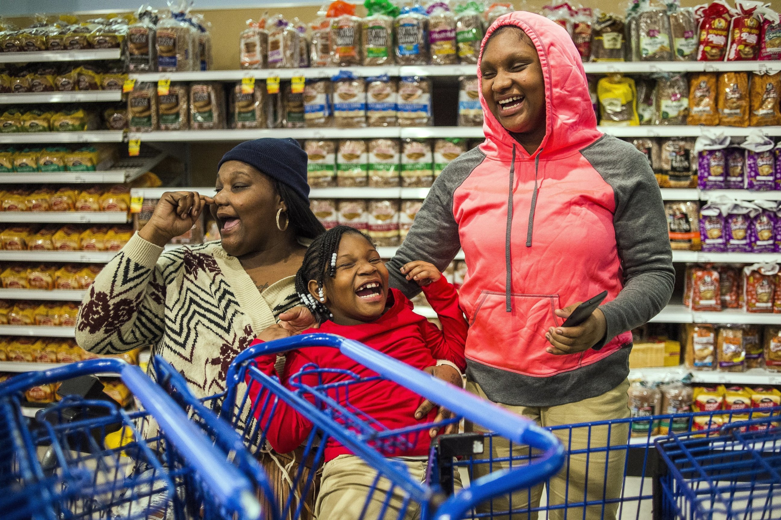 PHOTO: Flint resident Tiesha Taylor and her daughters Mariah, 7, and Kaerya, 12, laugh aloud together at an event inside a Meijer store in Burton, Mich. on Dec. 6, 2016.
