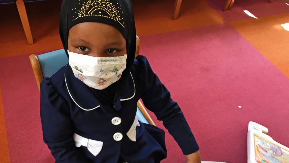 Amira Hassan, of Burnsville, Minn., plays in the waiting room at the specialty clinic at Children's Minnesota in Minneapolis, May 2, 2017. Hassan went to the hospital's clinic for a routine wellness check, but had to wear a mask to protect her from measles after an outbreak has sickened more than 30 children in Minnesota.
