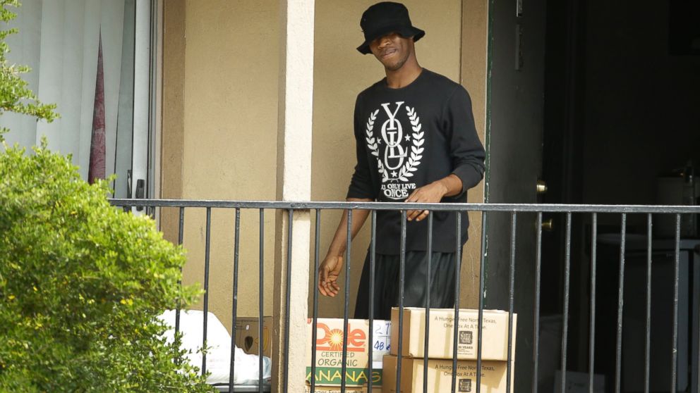 A man retrieves food and supplies left by the North Texas Food Bank and the Red Cross in front of a residence at The Ivy Apartments complex, Oct. 2, 2014, in Dallas.