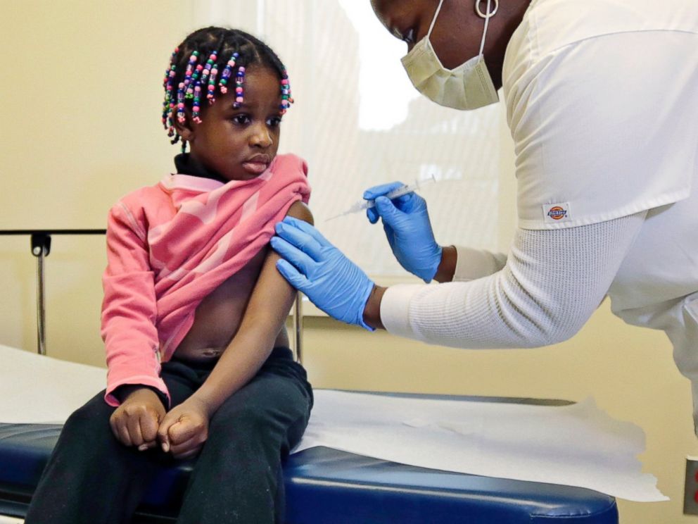 PHOTO: Four-year-old Gabriella Diaz sits as a nurse administers a flu shot at the Whittier Street Health Center in Boston, Mass. on Jan 9, 2013.