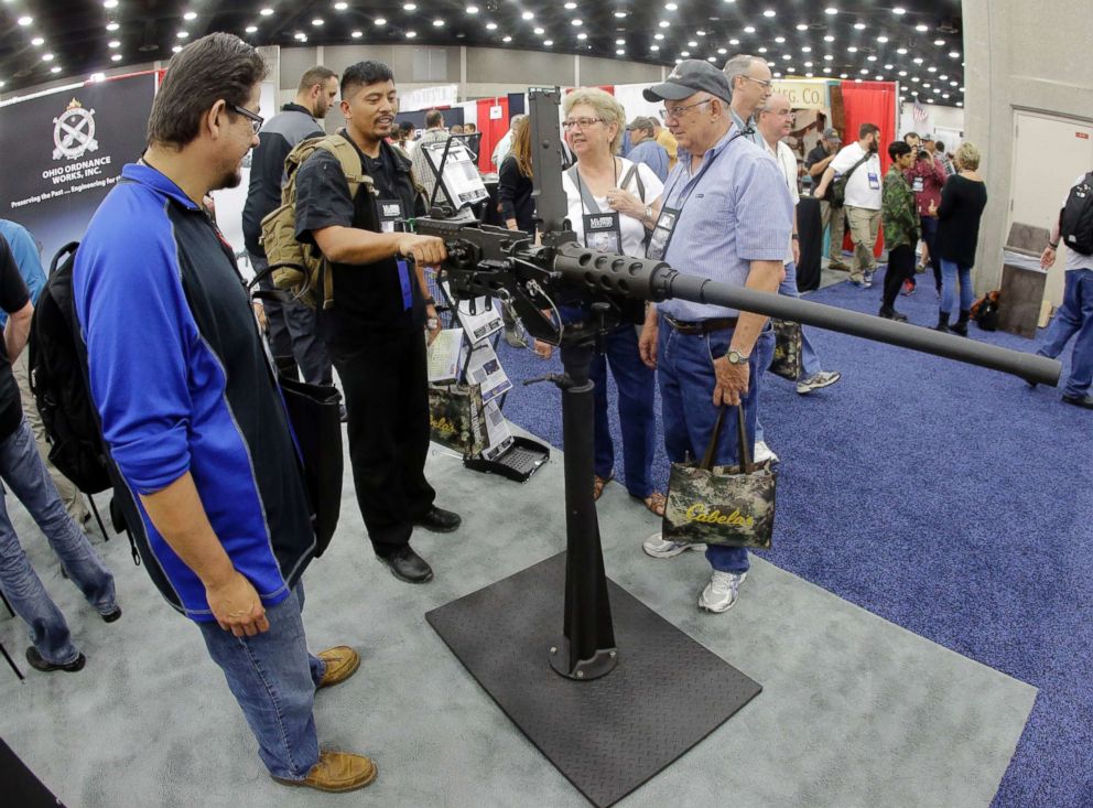 PHOTO: Retired Army Maj. Noel Zarza, center, of Bloomington, Ill., examines a .50 caliber machine gun at the National Rifle Association convention Saturday, May 21, 2016, in Louisville, Ky. 