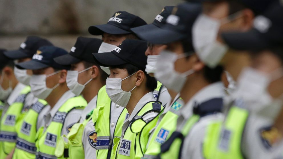 PHOTO: South Korean police officers wearing masks as a precaution against MERS stand guard during a rally in Seoul, South Korea, June 11, 2015. 