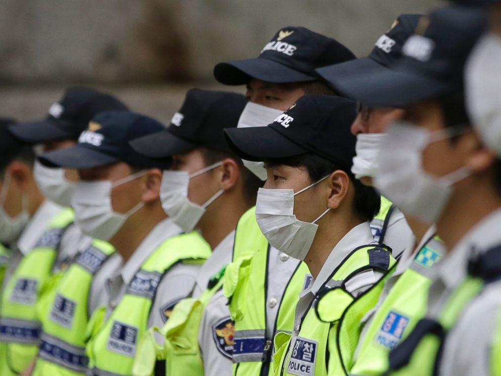 PHOTO: South Korean police officers wearing masks as a precaution against MERS stand guard during a rally in Seoul, South Korea, June 11, 2015.