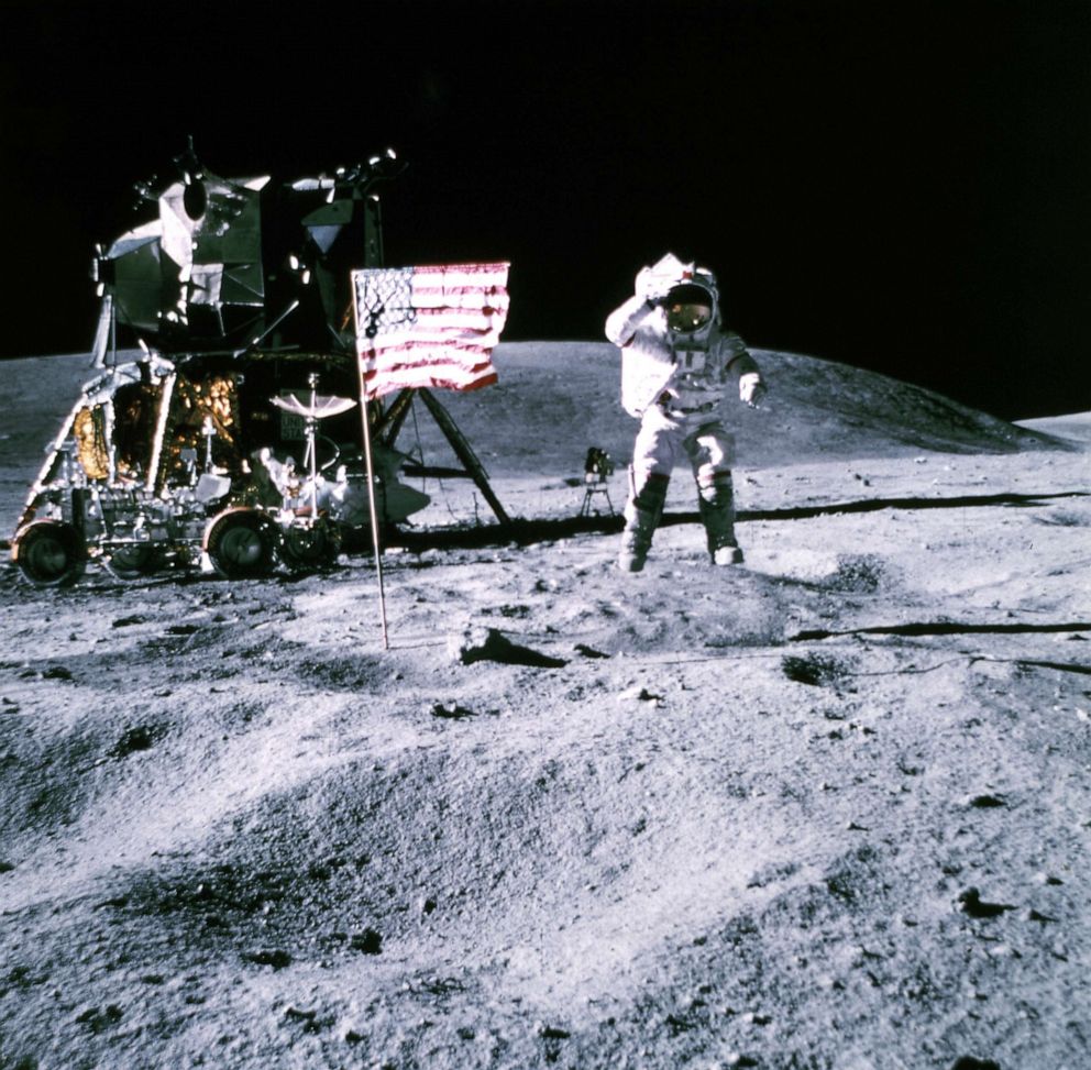 PHOTO: This November 19, 1969 photo released by NASA shows one of the astronauts of the Apollo 12 space mission standing on the Moon, the US flag on the Moon, and the Saturn Lunar Module.