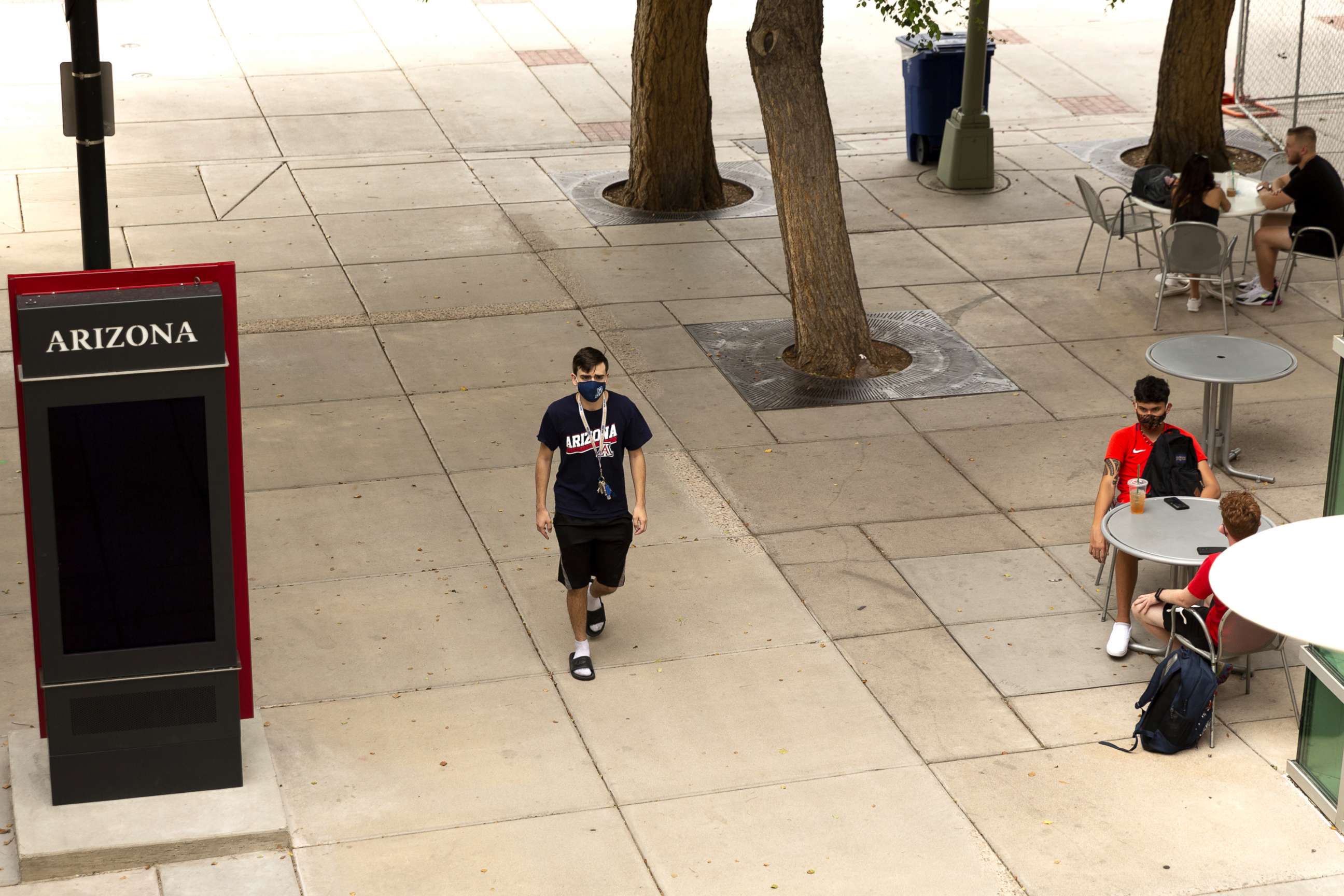 PHOTO: A student wears a protective mask while walking through the campus at the University of Arizona in Tucson, Ariz., Aug. 24, 2020.