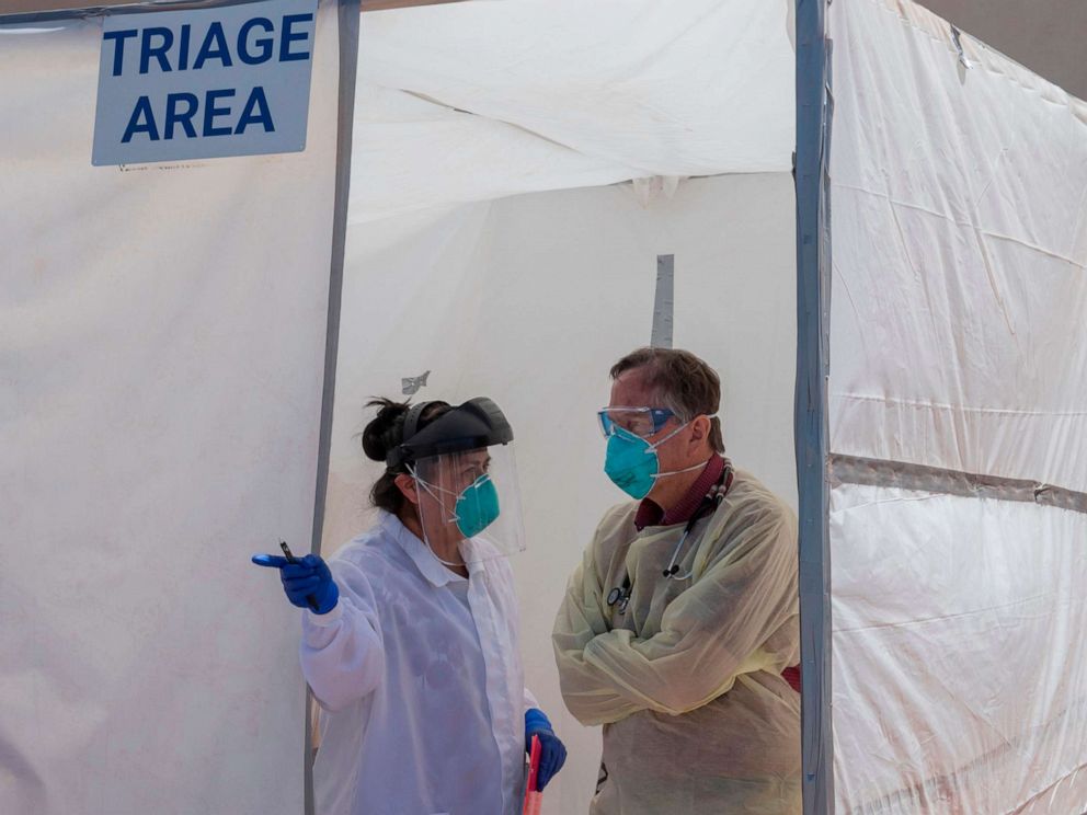 PHOTO: Medical staff discuss a patient's symptoms inside a Covid-19 testing center at the Navajo Nation town of Monument Valley in Arizona, May 21, 2020.