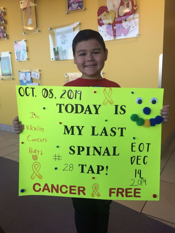 PHOTO: Steven Cotter holds a sign with the dates of his cancer treatments.