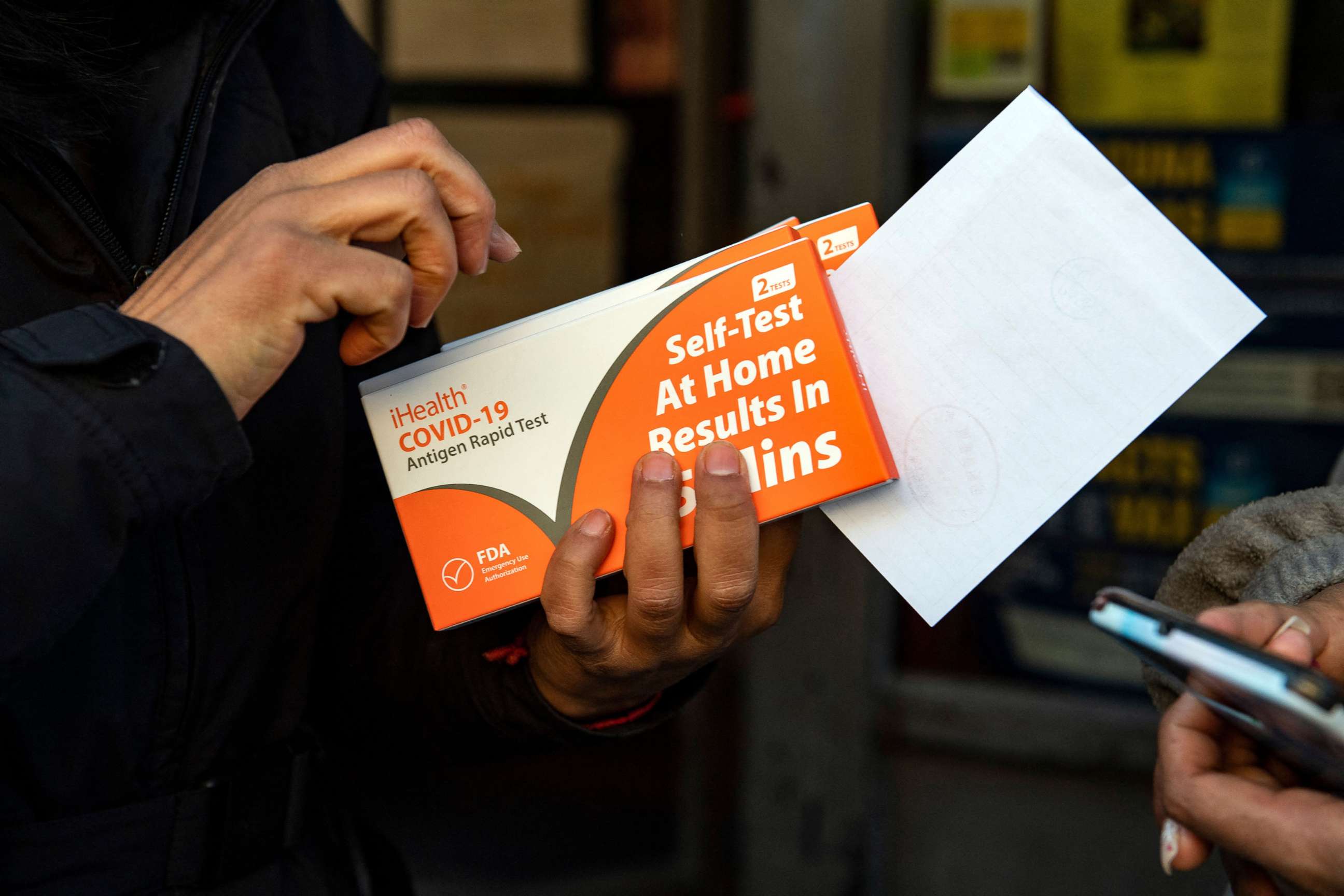 PHOTO: Irma Mazzoni, left, hands out rapid at-home COVID-19 test kits distributed by the GreenRoots environmental protection organization and Chelsea Community Connections in Chelsea, Mass., Dec. 17, 2021.