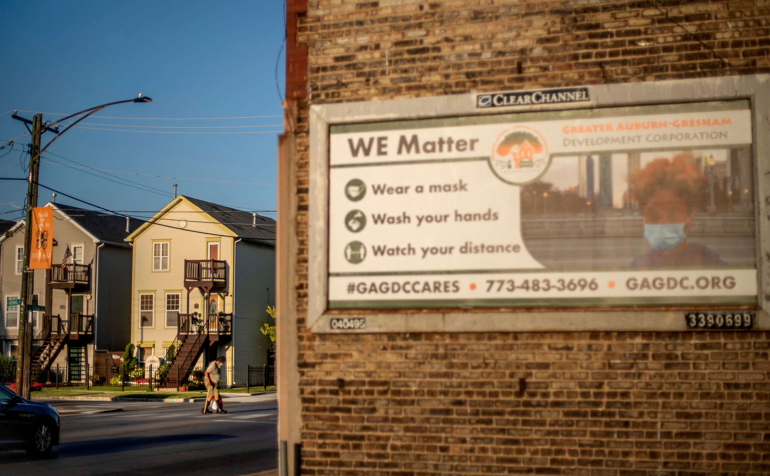 PHOTO: An elderly man crosses the street in the Auburn Gresham neighborhood next to a billboard promoting safety measures against COVID-19 in Chicago, Aug. 27, 2020.