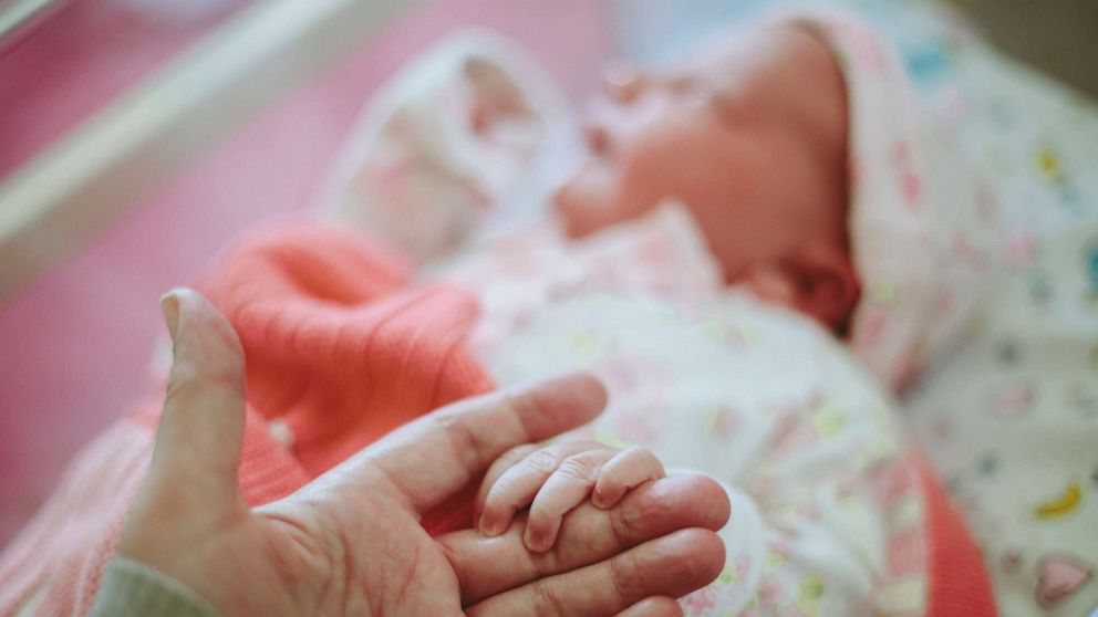 PHOTO: A newborn baby holds a hand in an undated stock photo.
