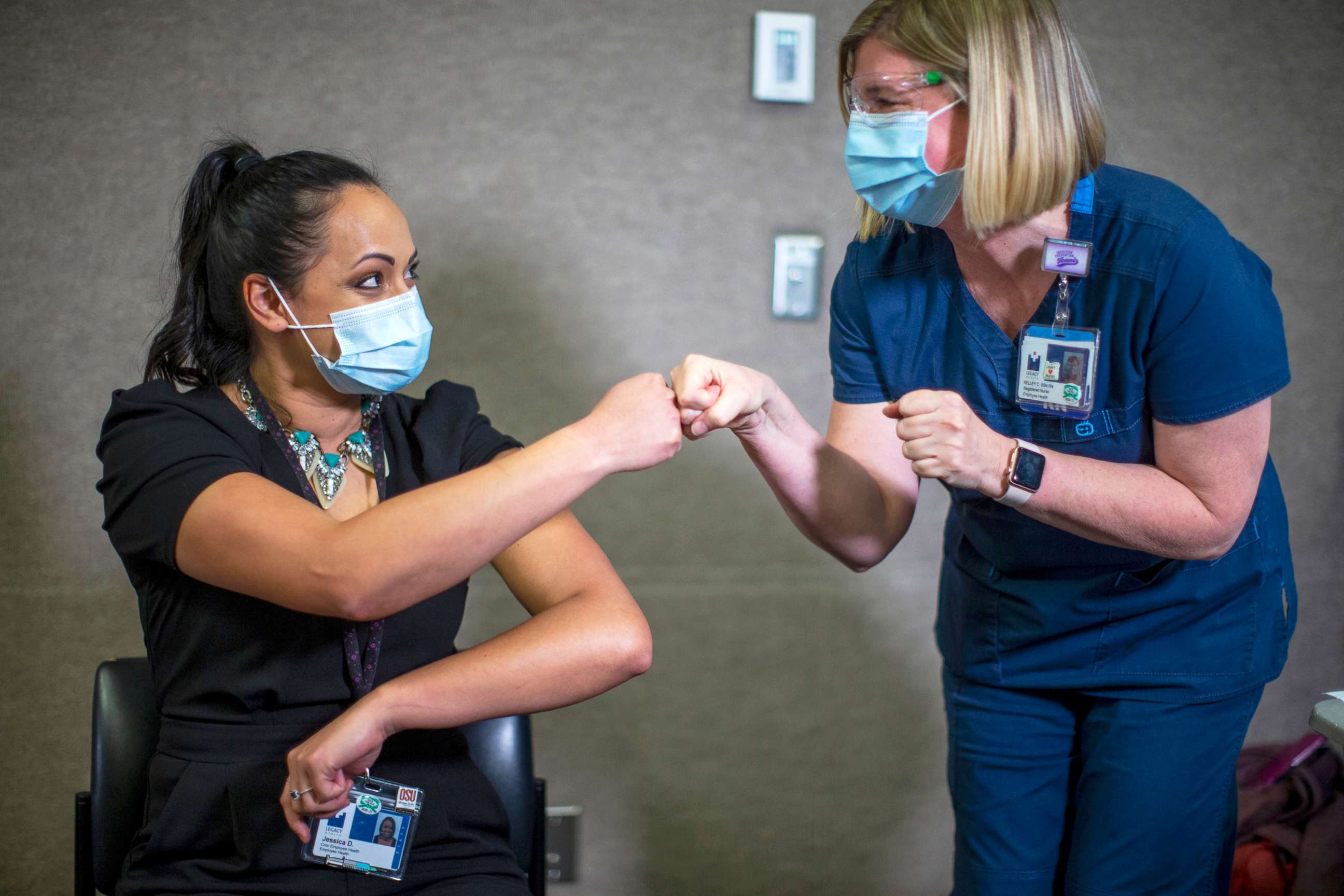 PHOTO: Jessica Daniels, right, immunization program coordinator for Legacy Emanuel, first-bumps Kelley Callais after Callais administered her COVID-19 vaccination shot in Portland, Ore., Dec. 16, 2020.