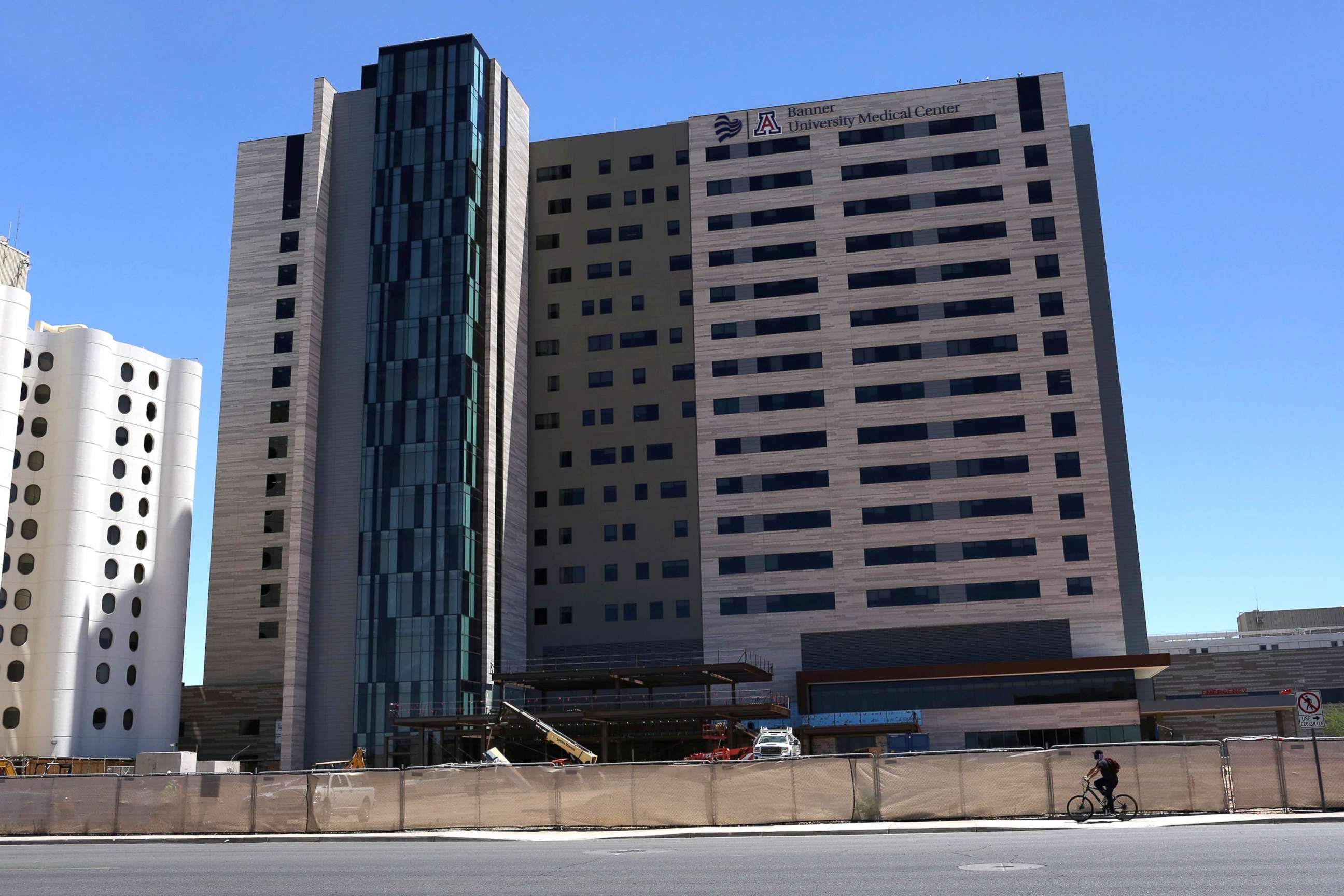 PHOTO: A biker with a face covering passes Banner - University Medical Center Phoenix, during the global outbreak of the coronavirus disease (COVID-19), in Phoenix, June 18, 2020.    