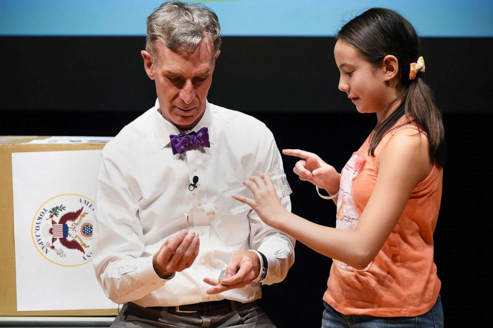 PHOTO: Scientist and educator Bill Nye performs with the help of a young audience member at the National Museum of Emerging Science and Innovation, Aug. 6, 2015 in Tokyo.