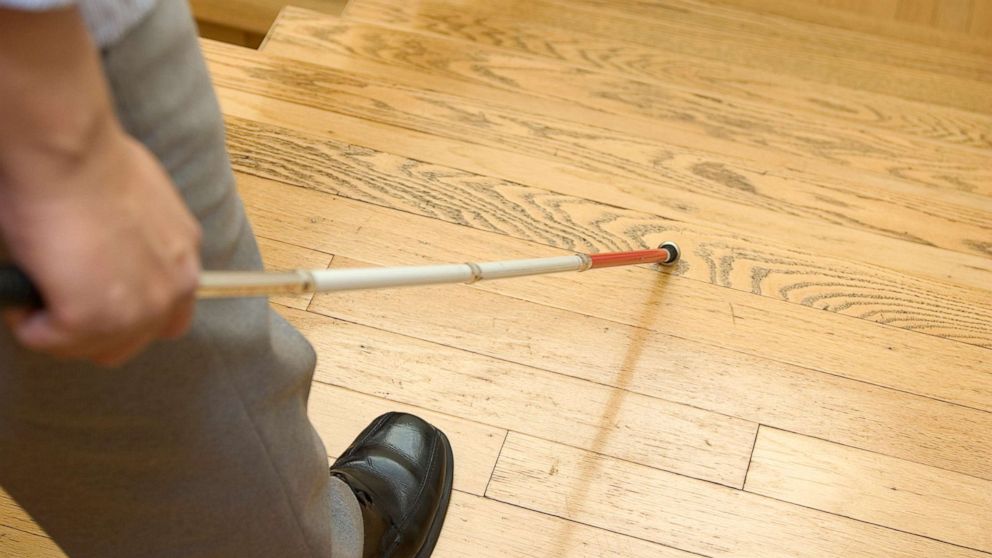 PHOTO: A blind man uses a white cane at home.