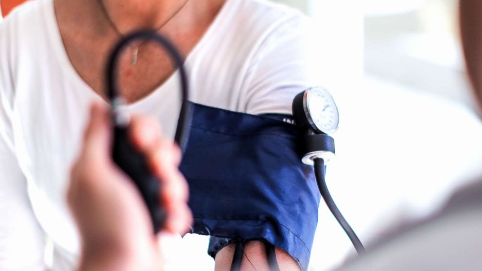 A doctor takes a patients blood pressure.