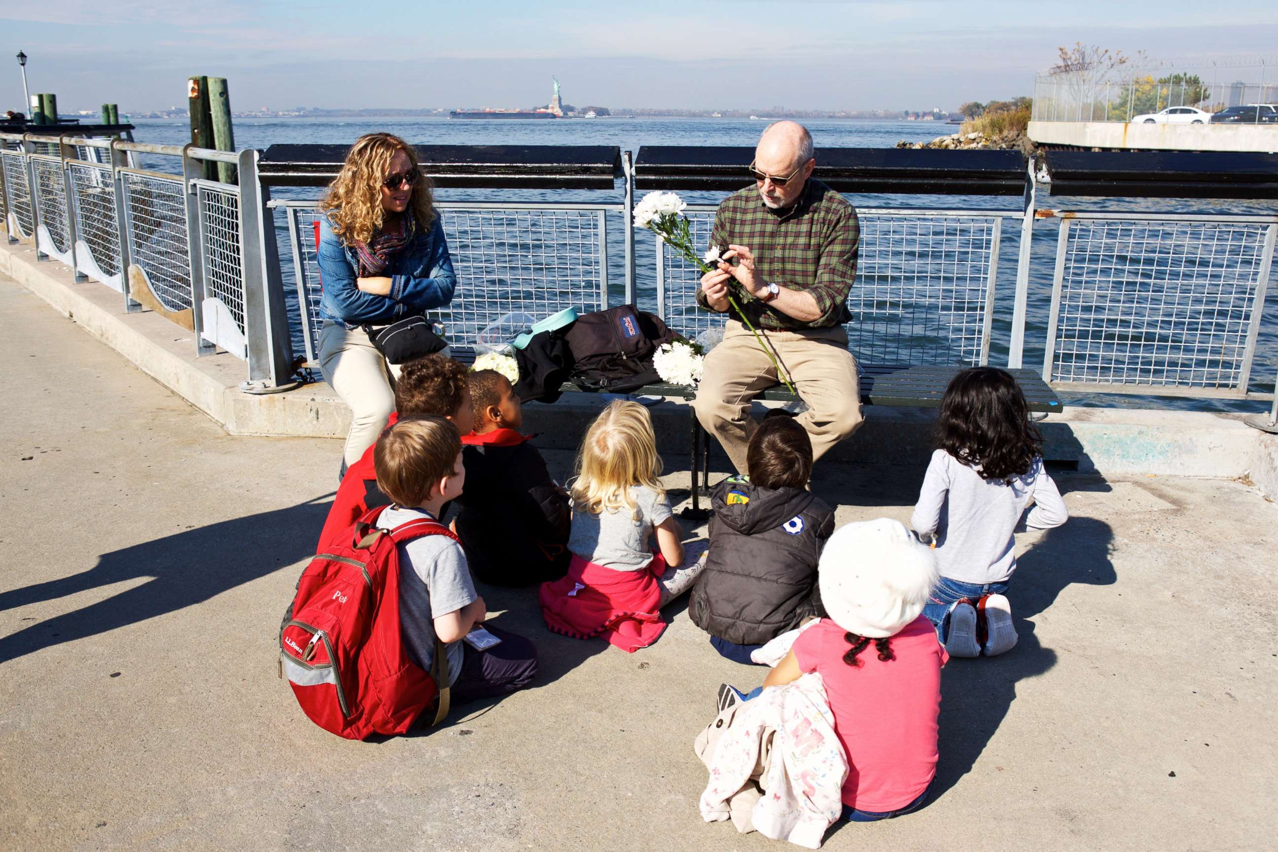 PHOTO: A Brooklyn New School teacher discusses water currents as students prepare to drop flower petals from Valentino Pier in Red Hook, Brooklyn into the East River to observe the current.