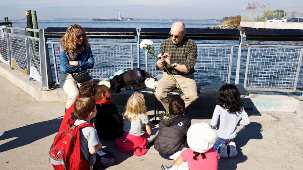 PHOTO: A Brooklyn New School teacher discusses water currents as students prepare to drop flower petals from Valentino Pier in Red Hook, Brooklyn into the East River to observe the current.
