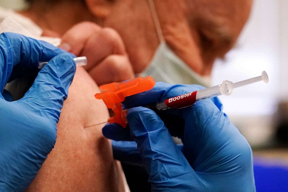 PHOTO: Pharmacist Kenni Clark gives Robert Champion a booster dose of the Moderna COVID-19 vaccine during a vaccination clinic at City of Lawrence's "The Center," which serves seniors, families and the community, Dec. 29, 2021, in Lawrence, Mass.