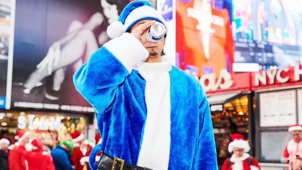 PHOTO: A person dressed as Santa Claus drinks a beer at Father Duffy Square for SantaCon on Dec. 14, 2019 in New York City. Every year, people dress up as Santa Claus or in other holiday-themed costumes and drink at multiple bars across the city.
