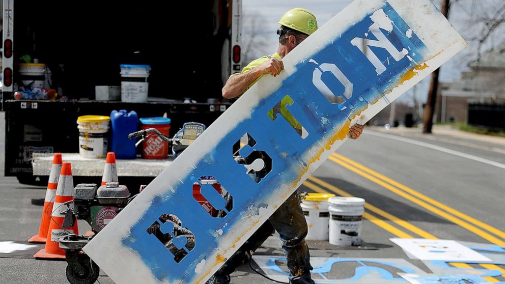 PHOTO: A worker paints the starting line for the 126th Boston Marathon, April 13, 2022, in Boston.