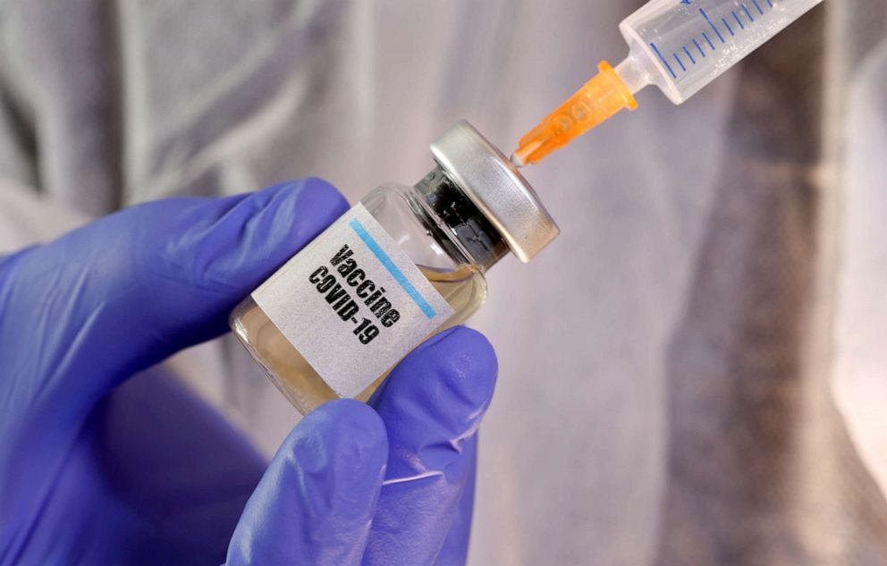 PHOTO: A woman holds a small bottle labeled with a "Vaccine COVID-19" sticker and a medical syringe in this illustration taken on April 10, 2020.
