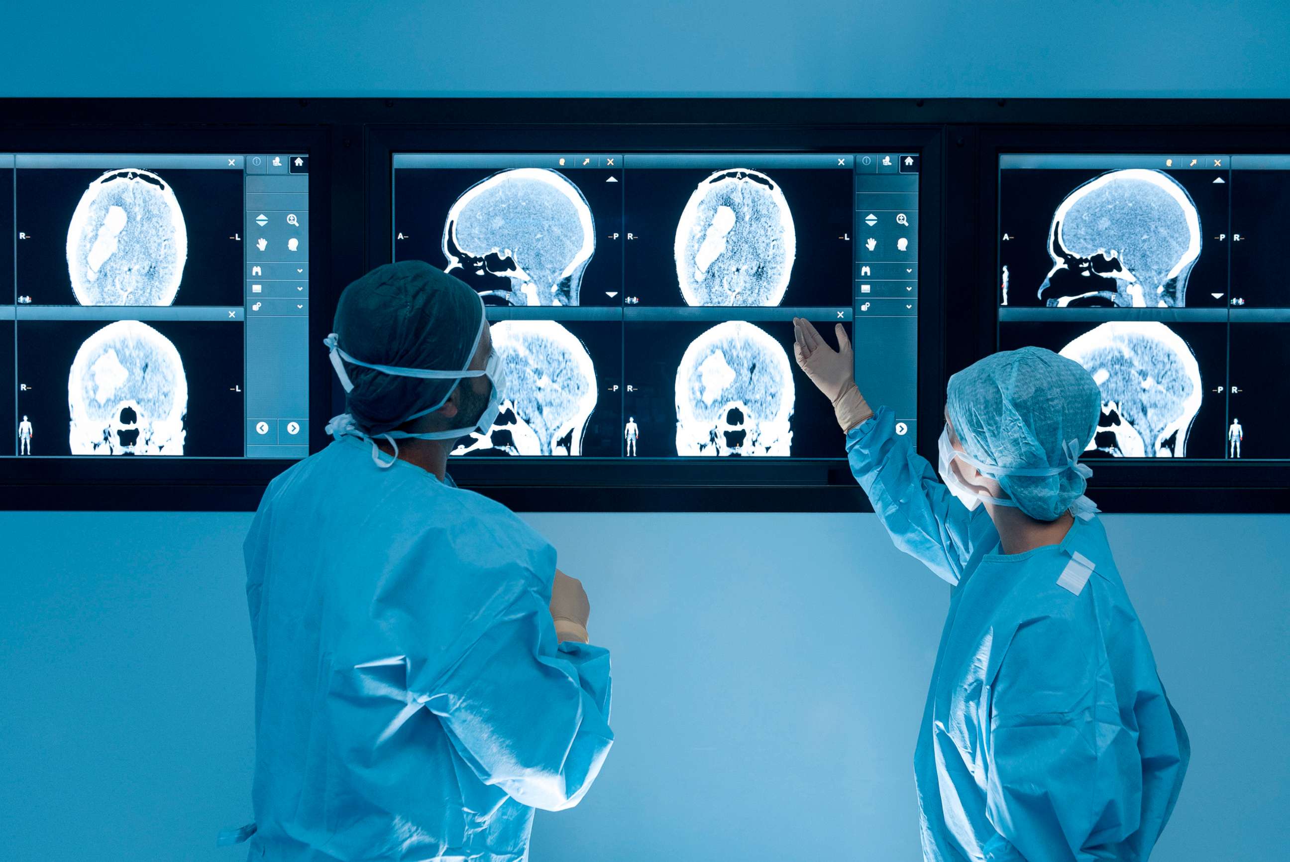 PHOTO: Surgeons looking at magnetic resonance imaging (MRI) brain scans during brain surgery.