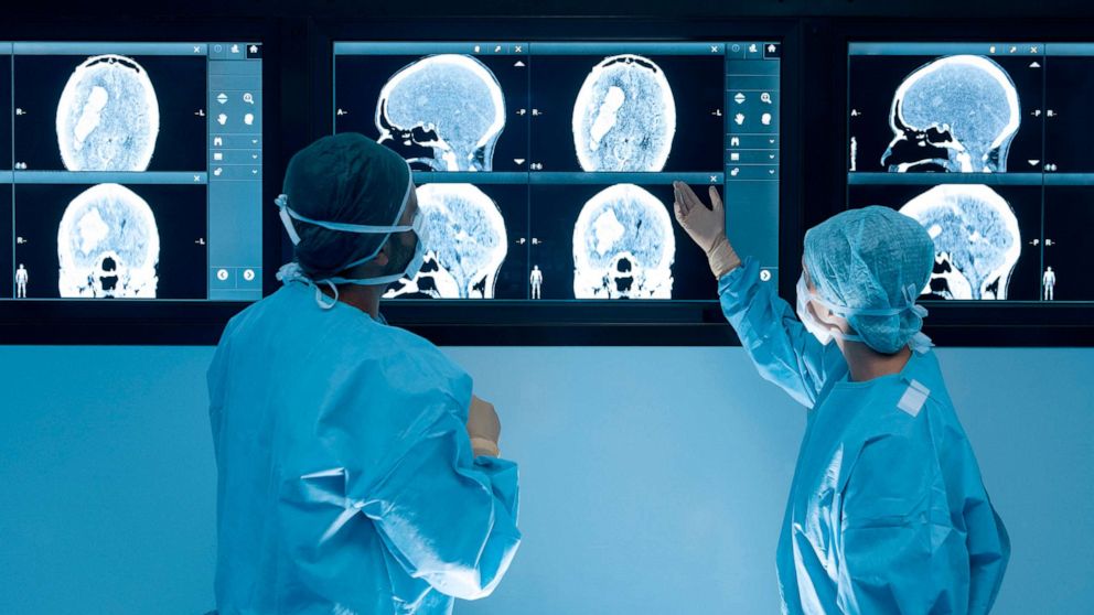 PHOTO: Surgeons looking at magnetic resonance imaging (MRI) brain scans during brain surgery.