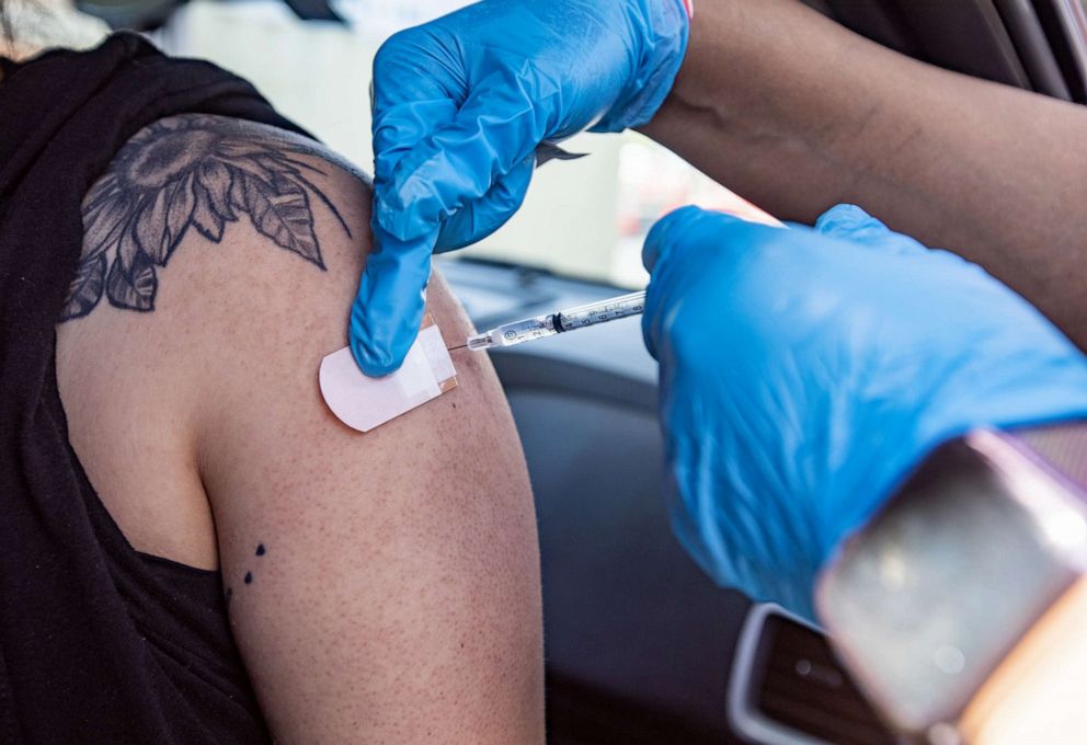 PHOTO: A healthcare worker administers a dose of the Pfizer-BioNTech Covid-19 vaccine at a drive-through clinic at California State University, Northridge (CSUN) in Northridge, Calif., May 13, 2021.