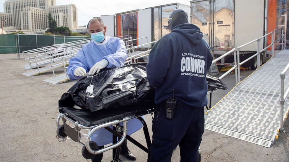PHOTO: L.A. County Medical Examiner-Coroner personnel prepare to load a container at a  temporary refrigerated storage facility for COVID-19 decedents in Los Angeles,  Jan. 27, 2021. 