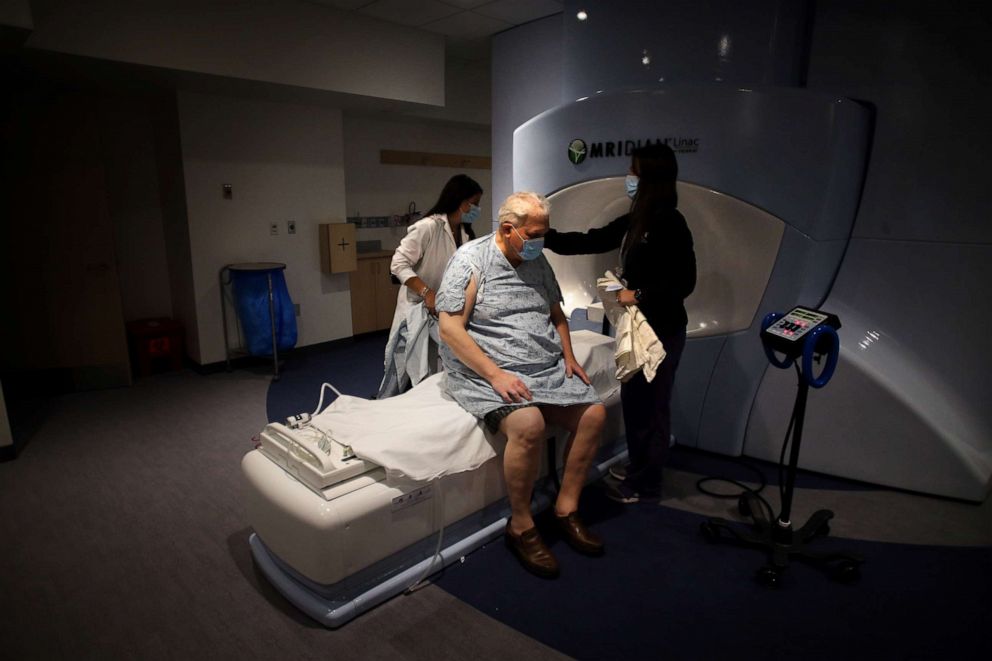 PHOTO: Radiation therapists Jessica Penney, left, and Jennifer Campbell, right, prepare cancer patient Kenton Fabrick for his treatment in the Radiation Oncology Department at Brigham and Women's Hospital in Boston, June 10, 2020.