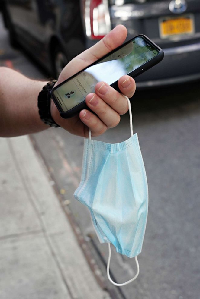 PHOTO: A person holds a cellphone and a protective mask on June 28, 2020, as New York City moves into phase 2 of reopening following restrictions imposed to curb the coronavirus pandemic.