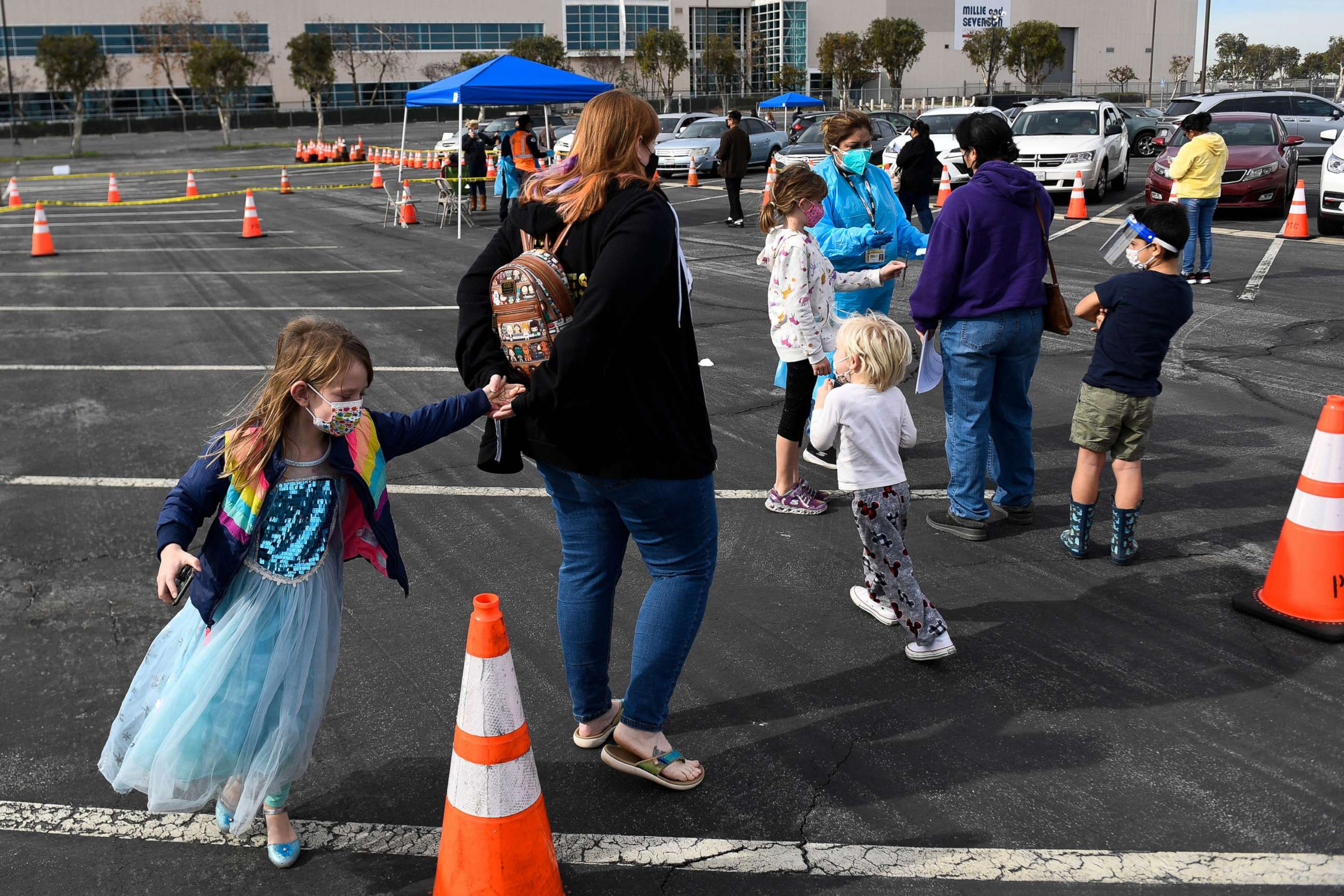 PHOTO: People with children sign up to receive rapid Covid-19 tests at a Long Beach Public Health Department testing site in the parking lot of a former Boeing aircraft factory, Jan. 10, 2022, in Long Beach, Calif.