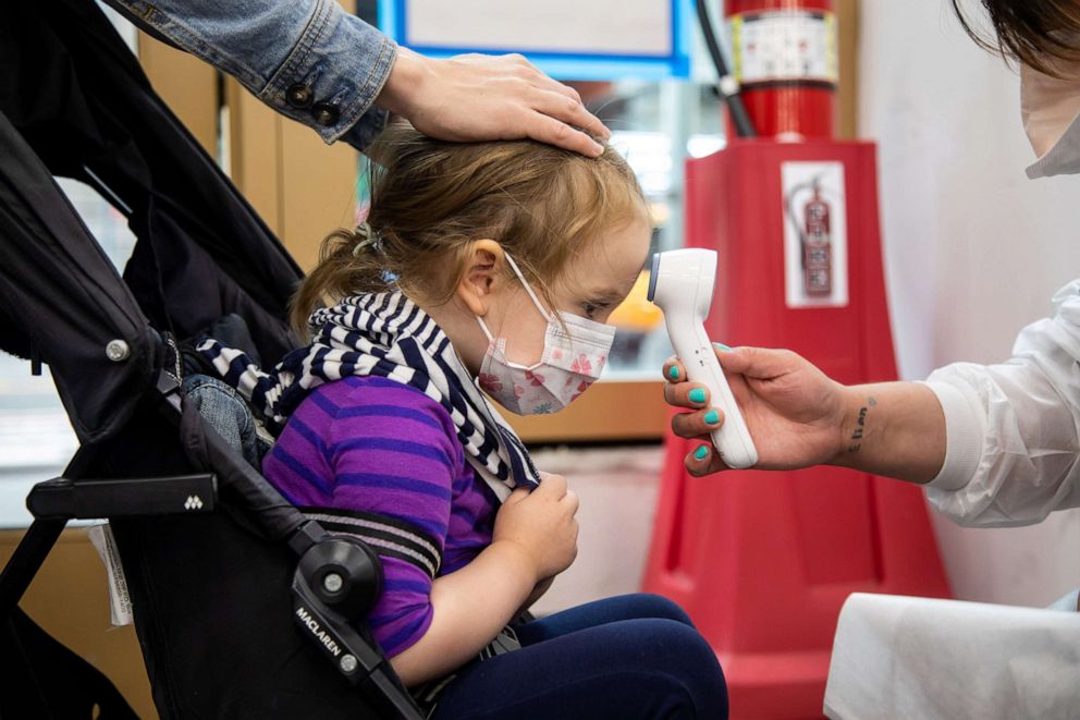 PHOTO: A girl has her temperature measured at a COVID-19 vaccination site in Times Square, New York, June 22, 2022. 