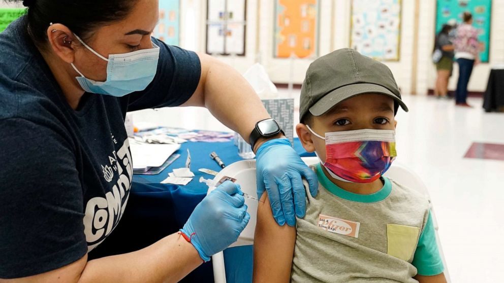 FILE PHOTO: Oliver Estrada, 5, right, receives the first dose of Pfizer's COVID-19 vaccine from medical assistant Patricia Munoz at an Adelante Healthcare community vaccine clinic at Joseph Zito Elementary School in Phoenix, Arizona, on Nov. 6, 2021.