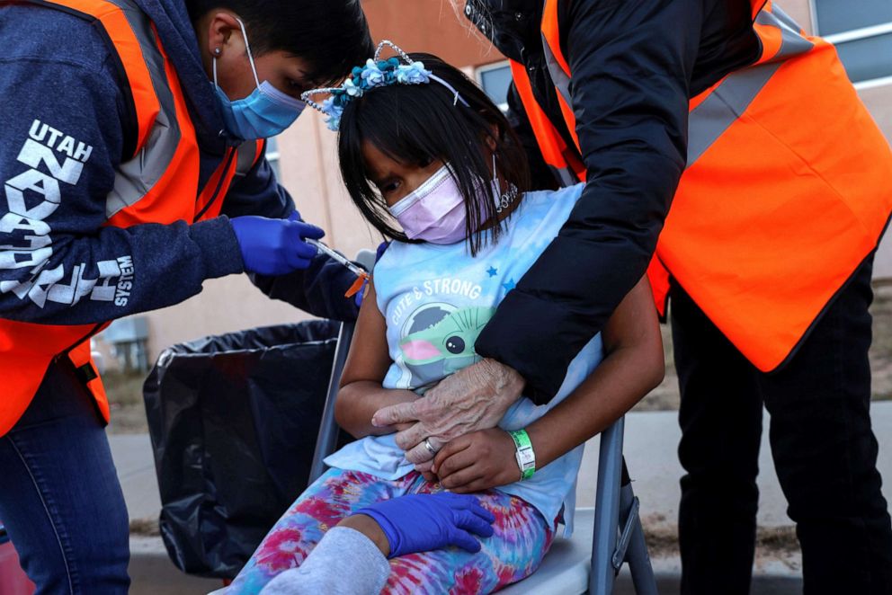 PHOTO: An 8-year-old girl is comforted while getting a dose of the Pfizer COVID-19 vaccine from members of the Utah Navajo Health System (UNHS), at a vaccination site for children ages 5-11 in the San Juan County of Aneth, Utah, Dec. 7, 2021.