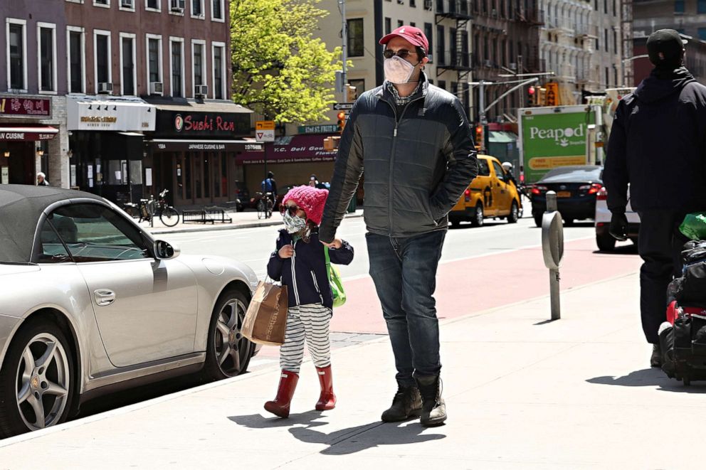 PHOTO: A man and child walk while wearing protective masks during the coronavirus pandemic on May 14, 2020, in New York.