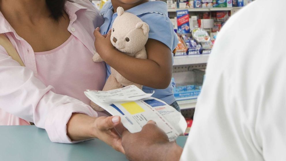 PHOTO: A mother picks up a prescription for her daughter in an undated stock photo.