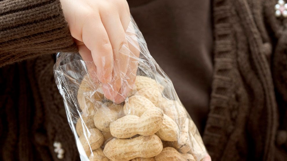 PHOTO: A young girl reaches into a bag of peanuts in an undated stock photo.