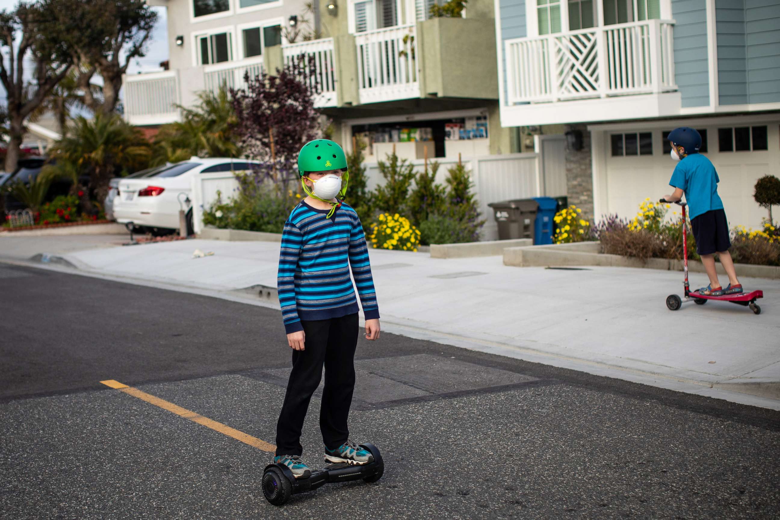 PHOTO: Children play in the streets while wearing face masks, in Redondo Beach, Calif., during the coronavirus pandemic and current safer-at-home orders from California Gov. Gavin Newsom, April 5, 2020.