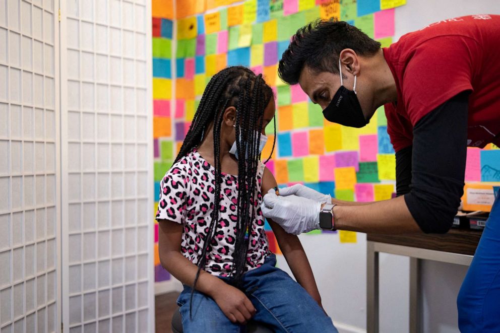 PHOTO: Dr. Mayank Amin puts a band-aid on 5-year-old Lydia Jones after receiving a Pfizer-BioNTech COVID-19 booster vaccine at Skippack Pharmacy in Schwenksville, Pa., May 19, 2022.