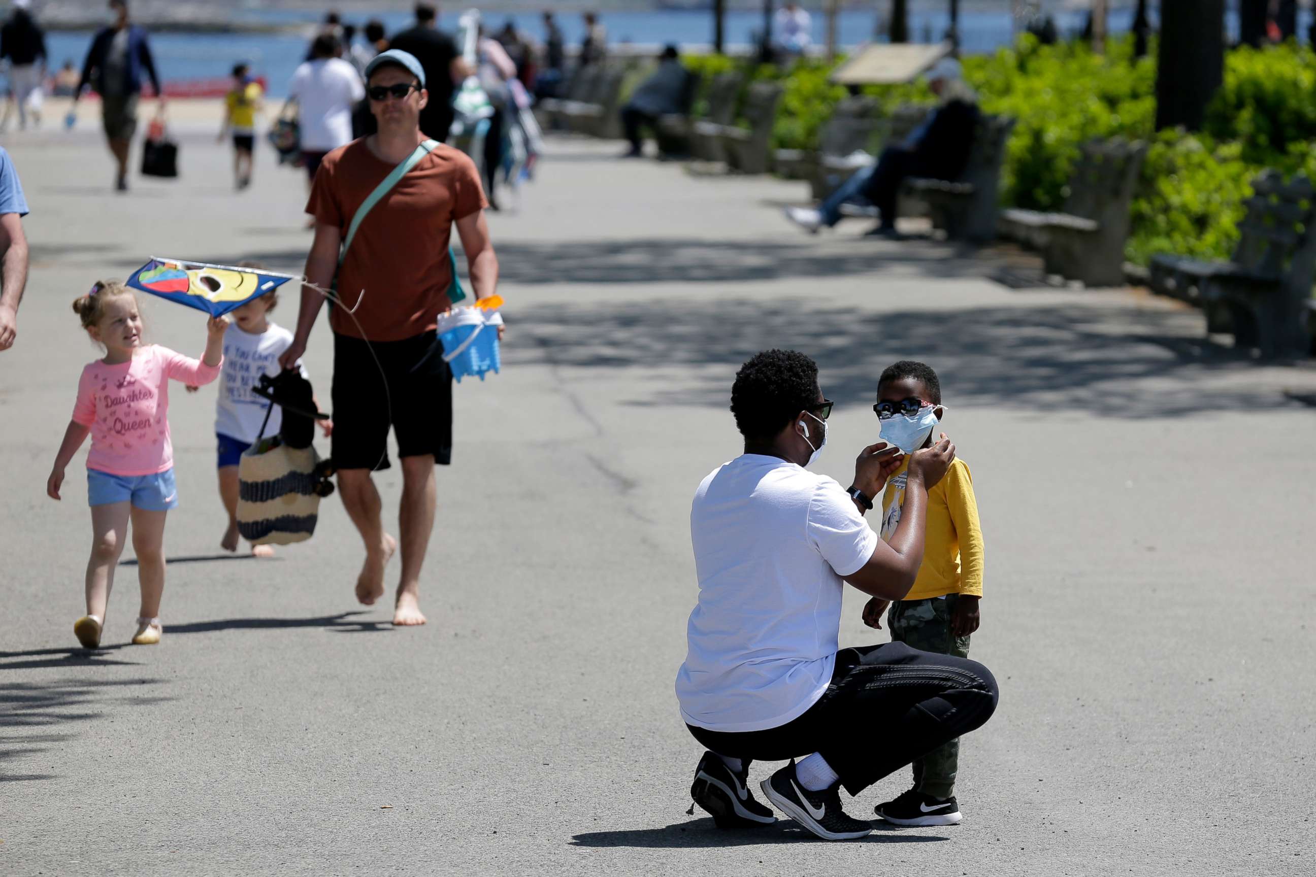 PHOTO: A man adjusts a child's mask before heading out to the sand at Orchard Beach in the Bronx borough of New York, May 17, 2020.