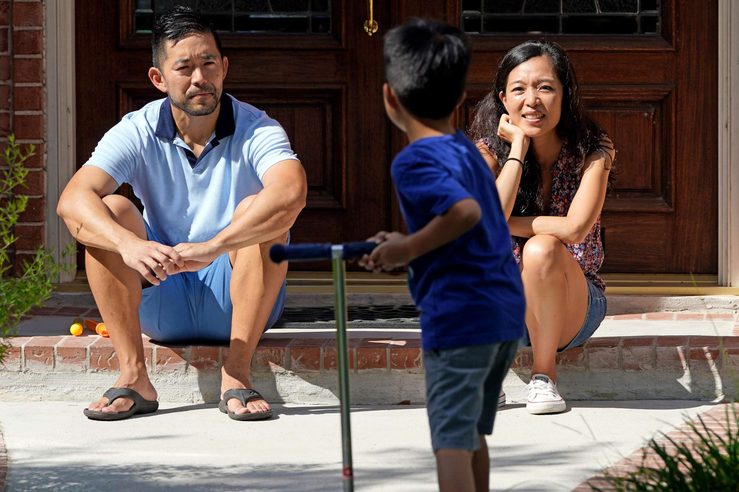 PHOTO: Vicky Li Yip, right, and her husband, Patrick, watch their son play outside their home, July 10, 2020, in Houston.