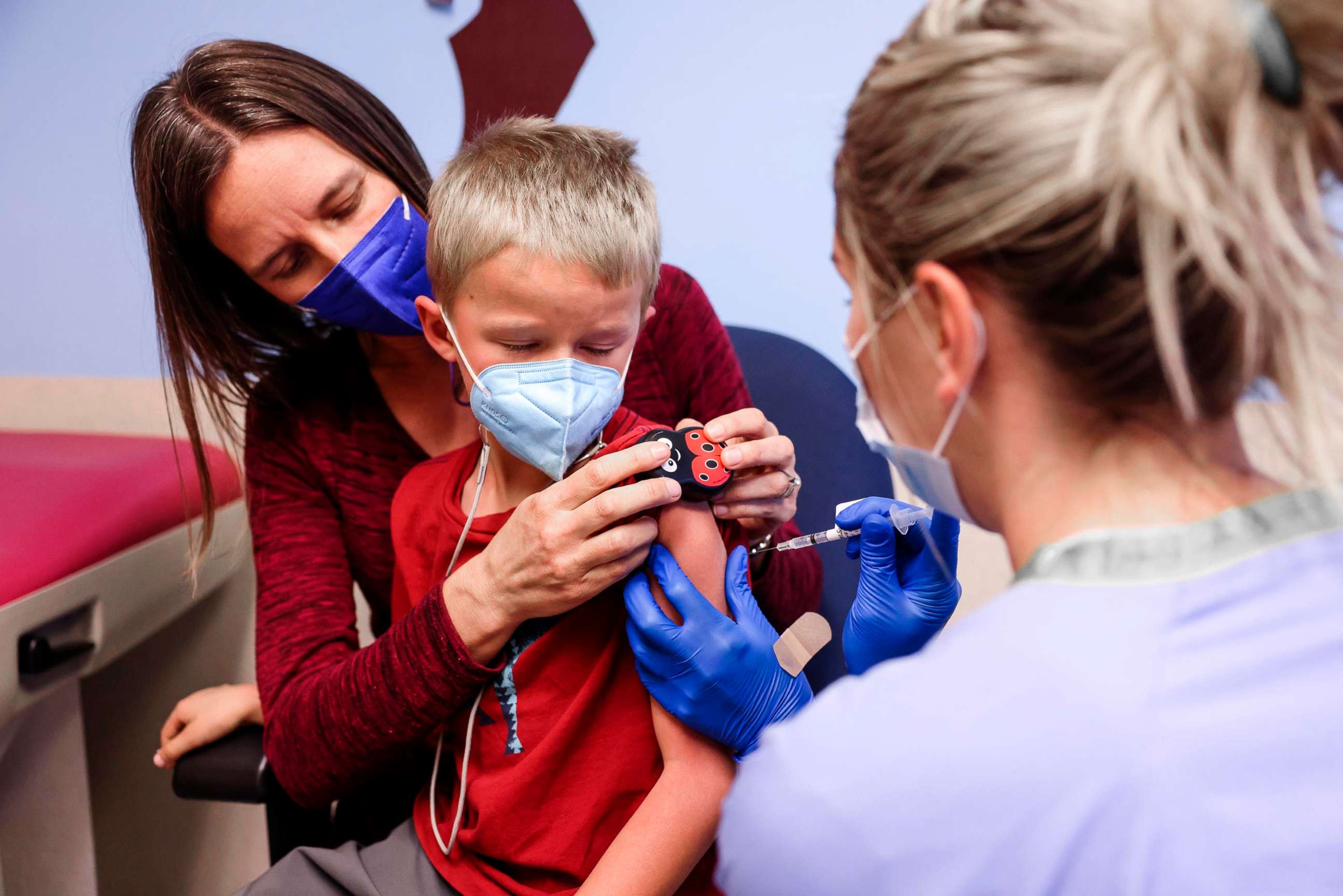 PHOTO: Jill Holm-Denoma comforts her son, Tyler, 5, as registered nurse Emily Cole administers a pediatric COVID-19 vaccine in Denver, Nov. 3, 2021.