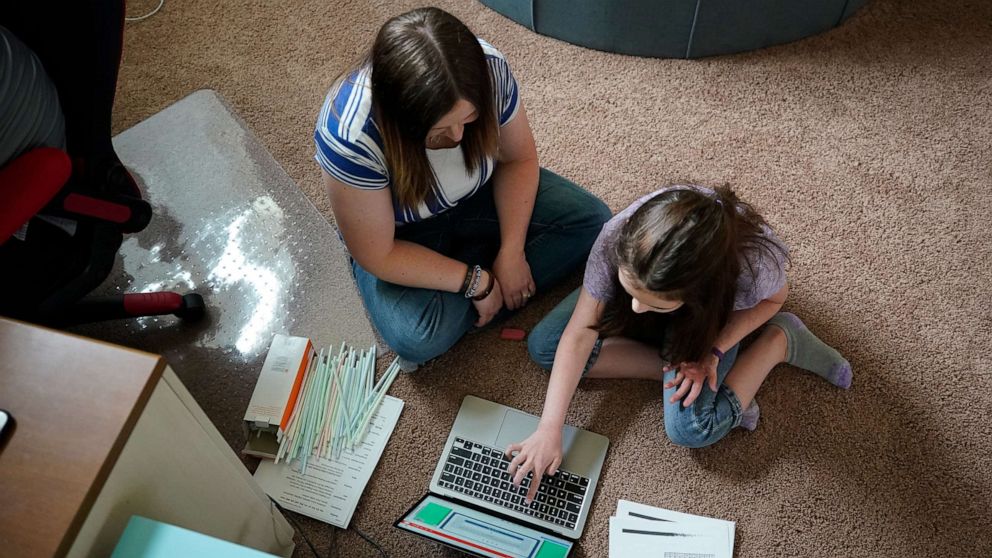 PHOTO: A mother assists her daughter with a remote learning class at their home in West Jordan, Utah, Sept. 8, 2020. 